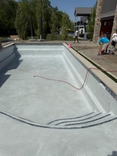 Plastered pool with curved entry steps and mosaic tile step markers