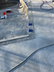 Fresh pool deck concrete work with plumbing lines during construction