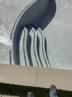 Detail of curved pool steps with tile step edging on new plaster