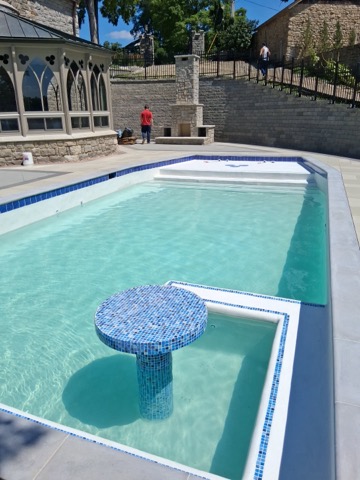 Rectangular pool with custom mosaic tile pedestal table and sun shelf