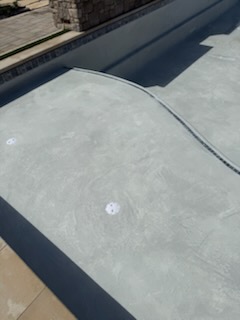 Close detail of new plaster finish, waterline tile and coping edge