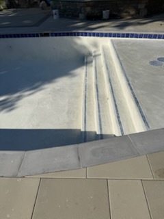 Wide entry steps with blue tile step markers in a newly finished pool